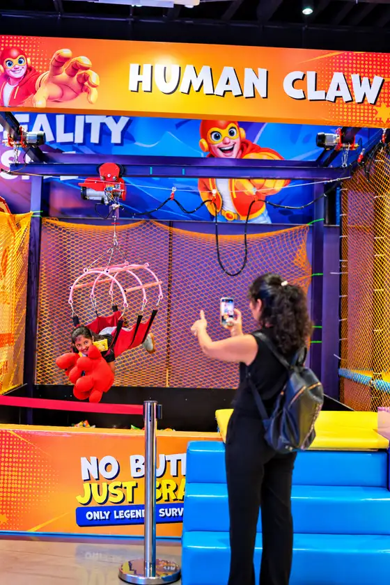 A visitor filming the Human Claw prize game